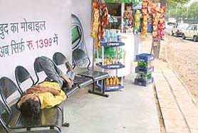 As the temperature of City Beautiful came down on Saturday due to a drizzle, a man takes a nap at a bus stop along the Madhya Marg.