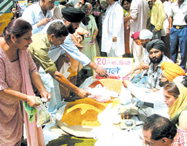 People form a long queue to buy dal from the activists of the National Akali Dal during a demonstration against the failure of the Delhi Government to check prices, at Gurdwara Bangla Sahib in the Capital on Sunday.