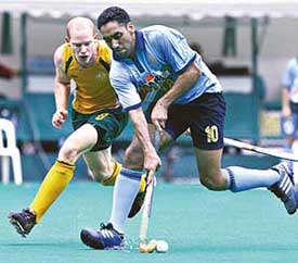 Australias Rober Hammond attempts to wrestle the ball from Tejbir Singh during the Sultan Azlan Shah hockey tournament in Kuala Lumpur