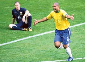Brazilian forward Adriano celebrates his goal as Australian defender Scott Chipperfield look dejected in their Group F match in Munich on Sunday