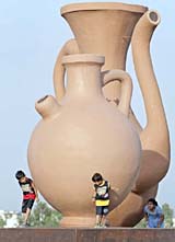 Children play near replicas of oversized Mughal-era ceramic vessels at the newly built Jinnah Public Park in Rawalpindi on Sunday. The park spreads over 40 acres and replaces the city's old prison where late Pakistani Prime Minister Zulfikar Ali Bhutto was hanged on April 4, 1979.