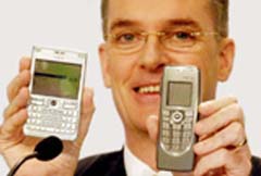 Mr Simon Beresford-Wylie, CEO-designate of Nokia Siemens Networks, poses with mobile phones during a press conference in Frankfurt, Germany