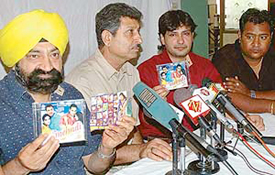 Jaspal Bhatti displays an original and pirated CD at a press conference in Chandigarh 