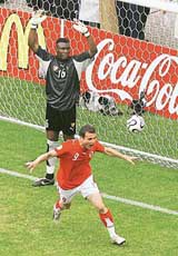 Switzerlands Alex Frei celebrates after scoring past Togos goalkeeper Kossi Agassa during their Group G match in Dortmund on Monday