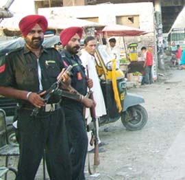Punjab Police Commandos stand guard at the entrance of the parking lot at the bus terminus in Jalandhar