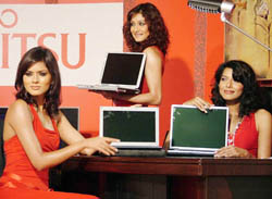 Models pose with newly launched laptops by Fujitsu in New Delhi