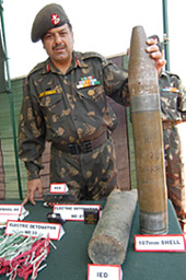 An Army officer holds a 107-mm shell, which was in a large cache of arms and ammunition seized from a militant hideout in Karnah, near the border town of Kupwara, on Wednesday.