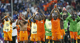 Members of the Ivory Coast team applaud after beating Serbia and Montenegro in their Group C match in Munich