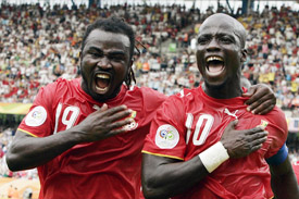 Ghanaian midfielder Stephen Appiah celebrates with forward Razak Pimpong after converting a penalty kick during the Group E match against the United States in Nuremberg on Thursday