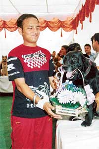 Dog trainer Vinod Kumar receiving a boquet of flowers from his tailed companion  a special wedding guest. 