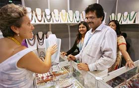 A French jewellery buyer confers with exhibitors at the jewellery and watch fair, 2006, at the Hong Kong Convention and Exhibition Centre