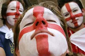 England soccer fans with their faces painted with a St. George cross wait in the centre of Stuttgart before England play Ecuador in the World Cup on Sunday