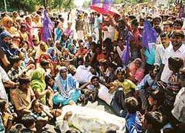 Residents of Kumhar Colony block the main road dividing Sectors 24/25, Chandigarh, in protest against the discontinuation of power supply to their colony on Wednesday.