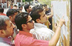 Aspiring candidates go through the cut-off lists for BCom and other courses at DAV College, Chandigarh, on Thursday