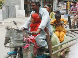 A man carries household goods on his two-wheeler along with three persons on a hot and humid day in Ludhiana on Thursday