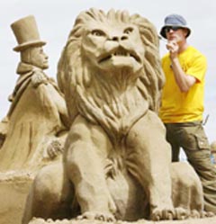 Irish sand sculptor Alan Magee works on a lion sculpture