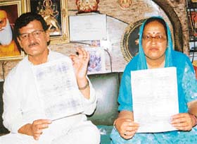 Mr Mohan Lal, a former BJP minister, along with Ms Nita Pathania, sarpanch of Donera village, show copies of an FIR registered against the latter, at a press conference in Pathankot