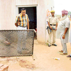 Police officials inspect the murder site at a wine shop in Mohi Kalan village near Rajpura on Sunday.
