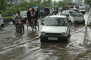 Travel becomes a chore for city residents on flooded roads. The first heavy downpour of the season hit the region on Monday.