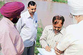 Mr Ashwani Kumar Singla, Executive Engineer, explains a point about necessary repairs at Jandali village.