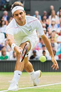 Roger Federer of Switzerland returns a shot to Mario Ancic of Croatia during their quarterfinal match on the Wimbledons Centre Court