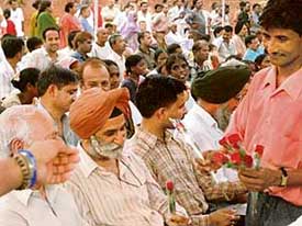 A man distributes roses to people during the inauguration of Mini Rose Garden in Sector 24, Chandigarh, on Saturday.