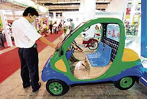 A man looks at a Chinese-made electric car at an Electric Bicycle and Green Transportation exhibition in Beijing on Sunday.