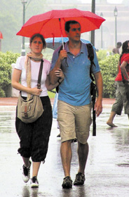 A couple take a walk as the first monsoon shower arrived belatedly in the Capital on Sunday. 