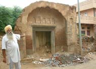 Charnjit Singh Fatehabad pointing towards the crumbling building that once housed General Mohan Singh, brother-in-law of Sardar Jassa Singh Ahluwalia, at Fatehabad