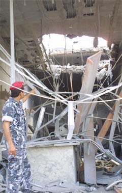 A Lebanese soldier points to a hole at a petrol station caused by Israeli air strikes in Khaiam, south Lebanon, on Friday.