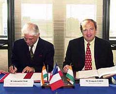 Indian Minister of State for Industry Ashwani Kumar signs documents as French Minister of Industry Franois Loos looks up in Paris