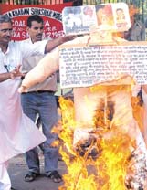 Activists of Loktantrik Samajwadi Party burning the effigies of Railway Minister Lalu Prasad Yadav, Maharashtra Chief Minister Vilas Rao Deshmukh and Pakistan President Pervez Musharraf, to protest against the Mumbai bomb blasts, at Jantar Mantar in the Capital on Sunday.