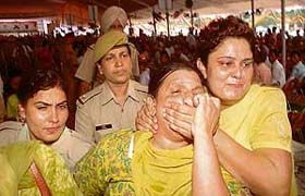 Women police personnel forcibly take away an unemployed teacher from the Chief Ministers rally at Phillaur