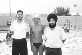 Jashandeep Singh (centre) along with his coach Surjit Singh and another swimming trainer Gangandeep at the Ropar swimming pool. 