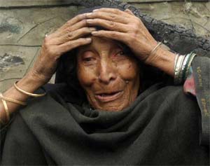 A Kashmiri old woman cries upon seeing her damaged house after a gunbattle between the security forces and suspected militants in Bandipora, 85 km north of Srinagar, on Monday