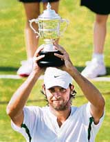 Mark Philippoussis of Australia holds the trophy after defeating Justin Gimelstob of the USA in the final of the Hall of Fame tennis championships in Newport, Rhode Island, on Sunday