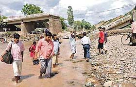 Local residents wade through the Markanda river on Friday.
