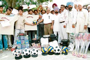 Samaj Bhalai Manch functionaries distribute sports equipment among village boys
