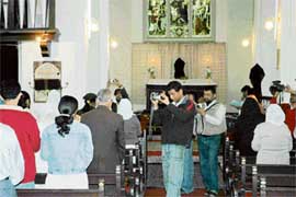 Shutterbugs take photographs during a service. 