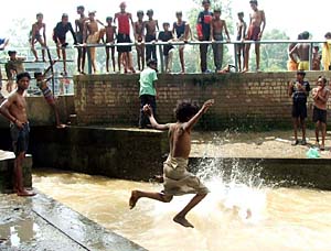 Young boys enjoy a dip in the water on a hot and humid day. The childhood joy of afternoon dips and no worries makes it a time to savour and remember later in life.
