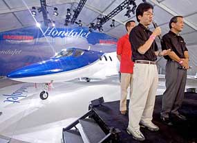Mr Michimasa Fujino, HondaJet Project Leader and Vice-President of Honda R&D Americas Inc., holding microphone answers queries on Tuesday at EAA Air Venture at a news conference in Oshkosh, Wis., as Mr Satoshi Toshida (right), senior Managing Director of Honda Motor Company, looks on.
