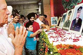 Dhruv Gularia, son of martyr, Capt Deepak Gularia, who died in Kargil war, paying floral tributes to his father during Vijay Divas function at Govt Museum, Sector 10, Chandigarh
