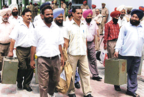 Officials with polling material on way to a polling venue for the Municipal Council election at Phase VI, Mohali, on Saturday.