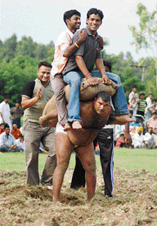 Wrestler Pappu Pehelwan lifts two men weighing 360 kg during the Rural Games in Ambala on Saturday