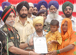 An Army officer hands over a provisional recruitment letter to Prince at Haldheri village in Kurukshetra on Sunday. 