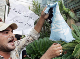 A Lebanese man sets fire to an UN flag at the entrance of the UN headquarters in Beirut on Sunday. Lebanese protesters broke into the UN headquarters smashing windows and ransacking offices, after an Israeli air strike in south Lebanon.
