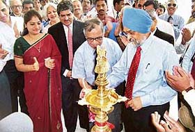 The Deputy Chairman of the Planning Commission, Dr Montek Singh Ahluwalia (right), lights up a lamp to inaugurate Software Development Block-4 on the Infosys campus in Mysore