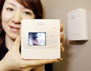 A Japanese electronics giant Sharp employee displays a new residential-use wireless camera monitoring system called "Living door-scope"