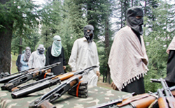 Militants walk past their weapons during a surrender ceremony in Baramulla, 55 km north of Srinagar