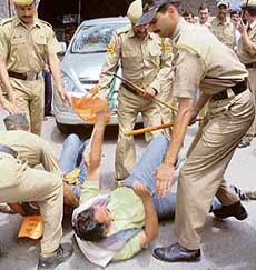 Police show batons to BJP activists as they particiapte in a chakka jaam agitation in Shimla on Tuesday.